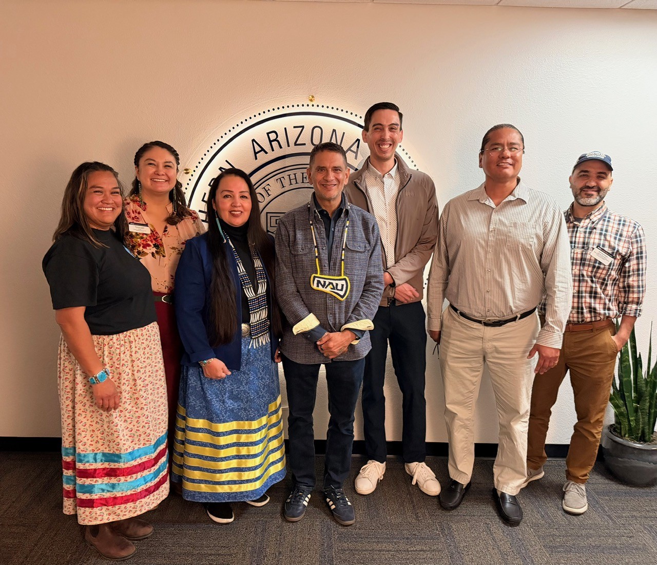 Skyler Benally-Bordeaux and staff/faculty pose for a picture with NAU President Rivera.