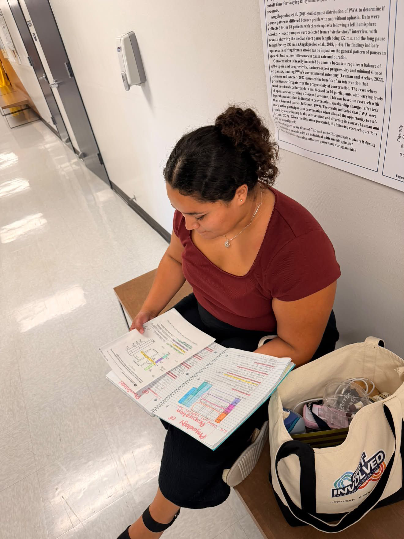 Nathalia Granados studying organized notes on a bench in the Health Professions building. 