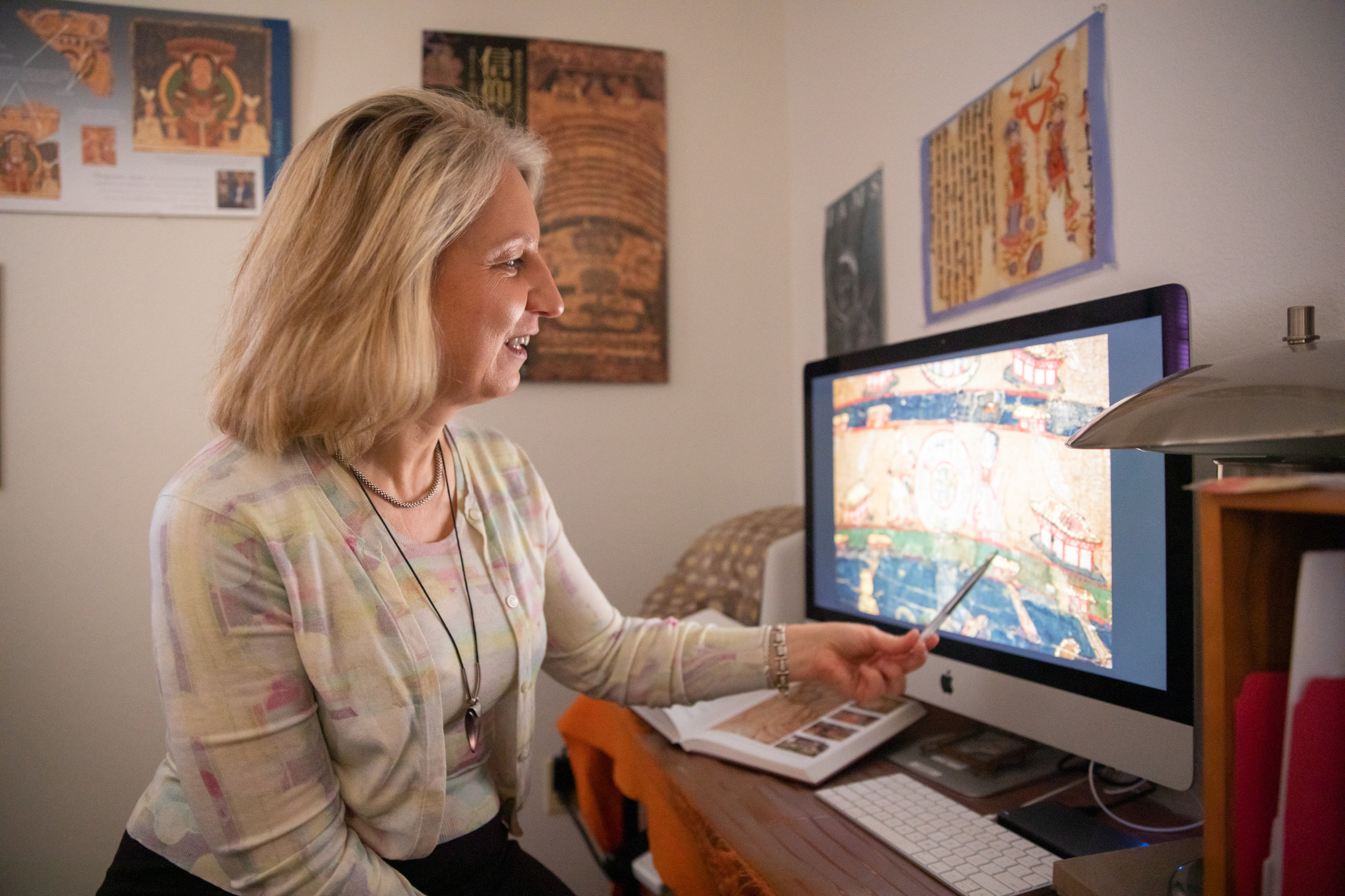 Faculty sitting in desk looking at a computer.