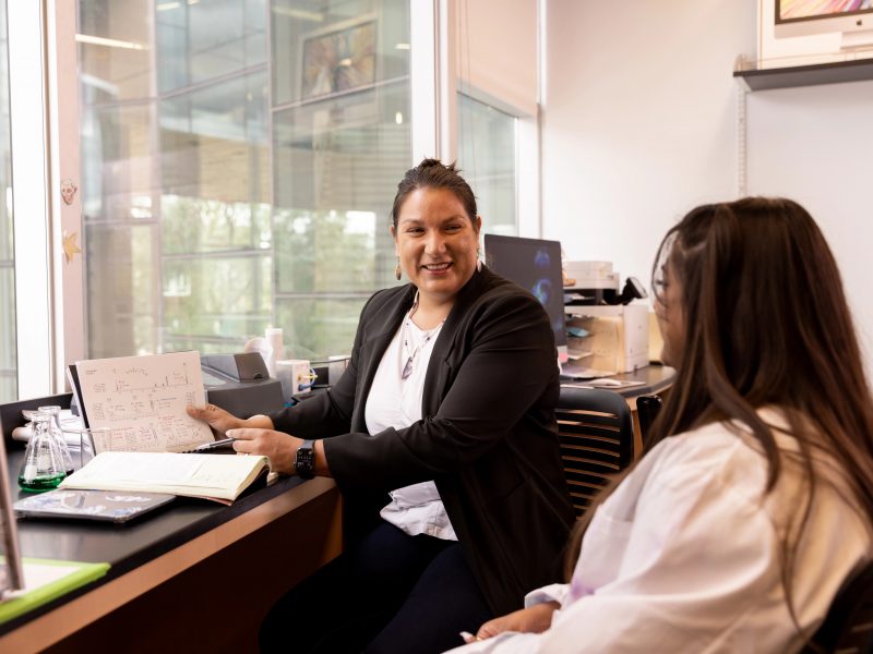 Faculty speaking to a student.
