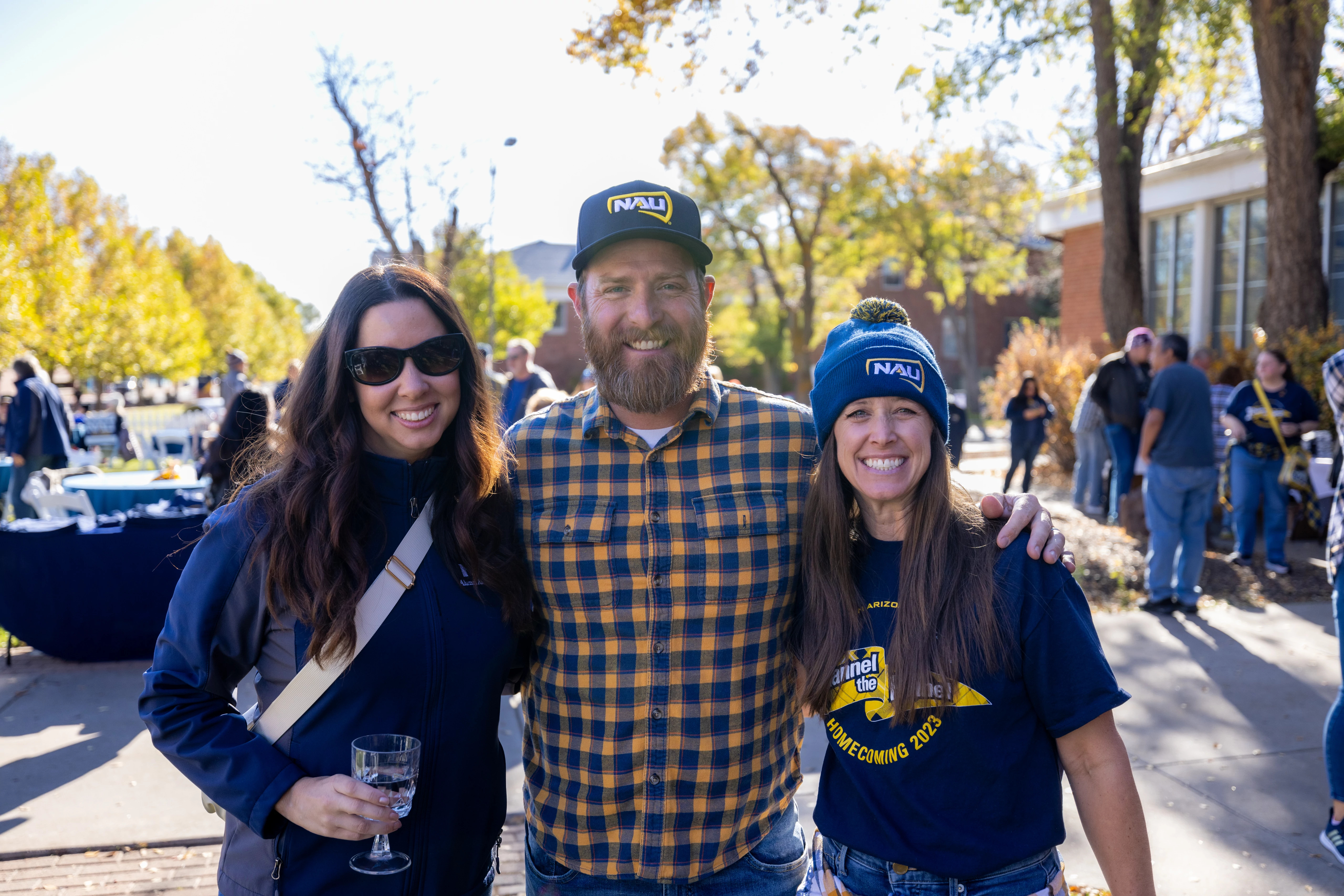 Northern Arizona University alumni outdoors smiling at camera.