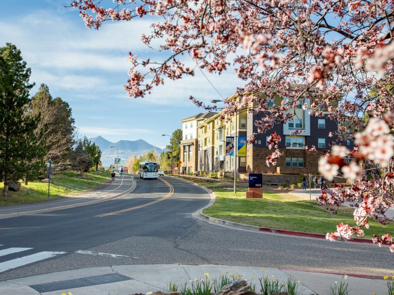 Campus shuttle driving down the road.