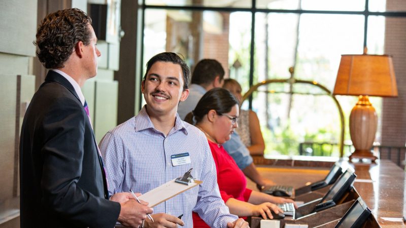 H R M student working with instructor.