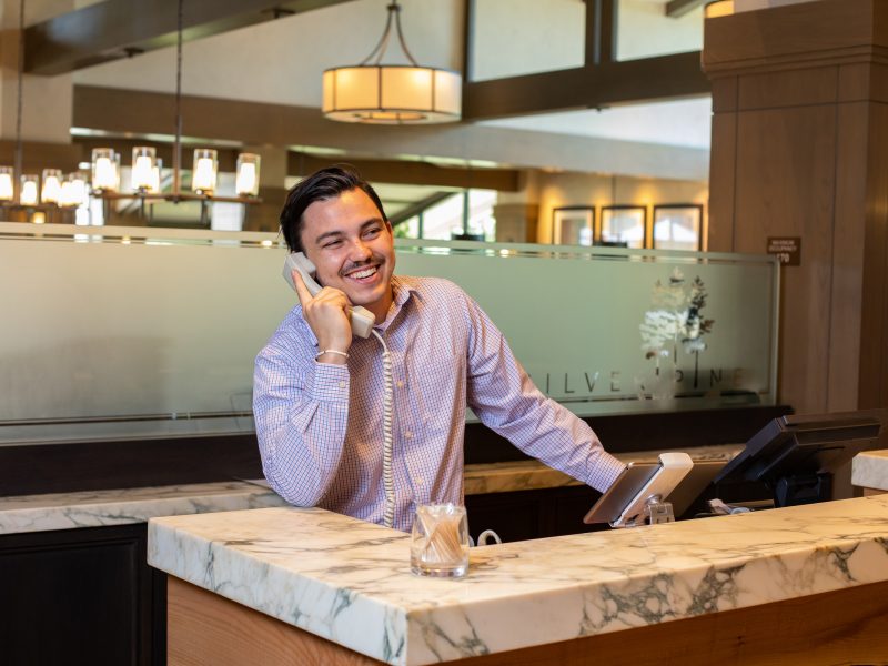 School of Hotel and Restaurant Management student answering phone while working at partner restaurant.