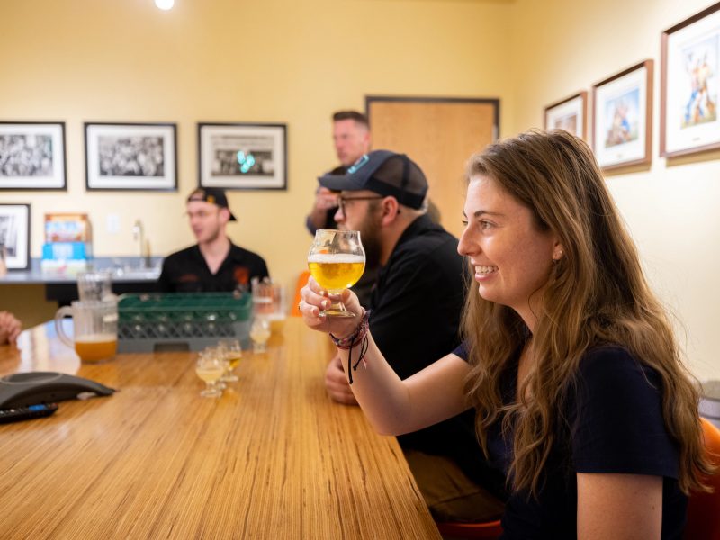Woman sits at Mother Road Brewery bar with a beverage.