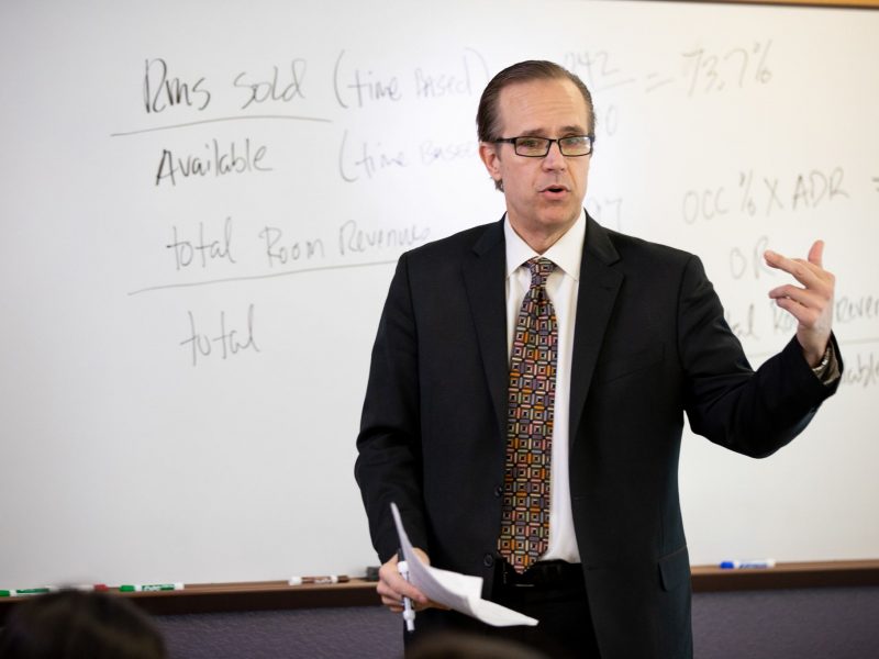 Professor teaching in front of a whiteboard.