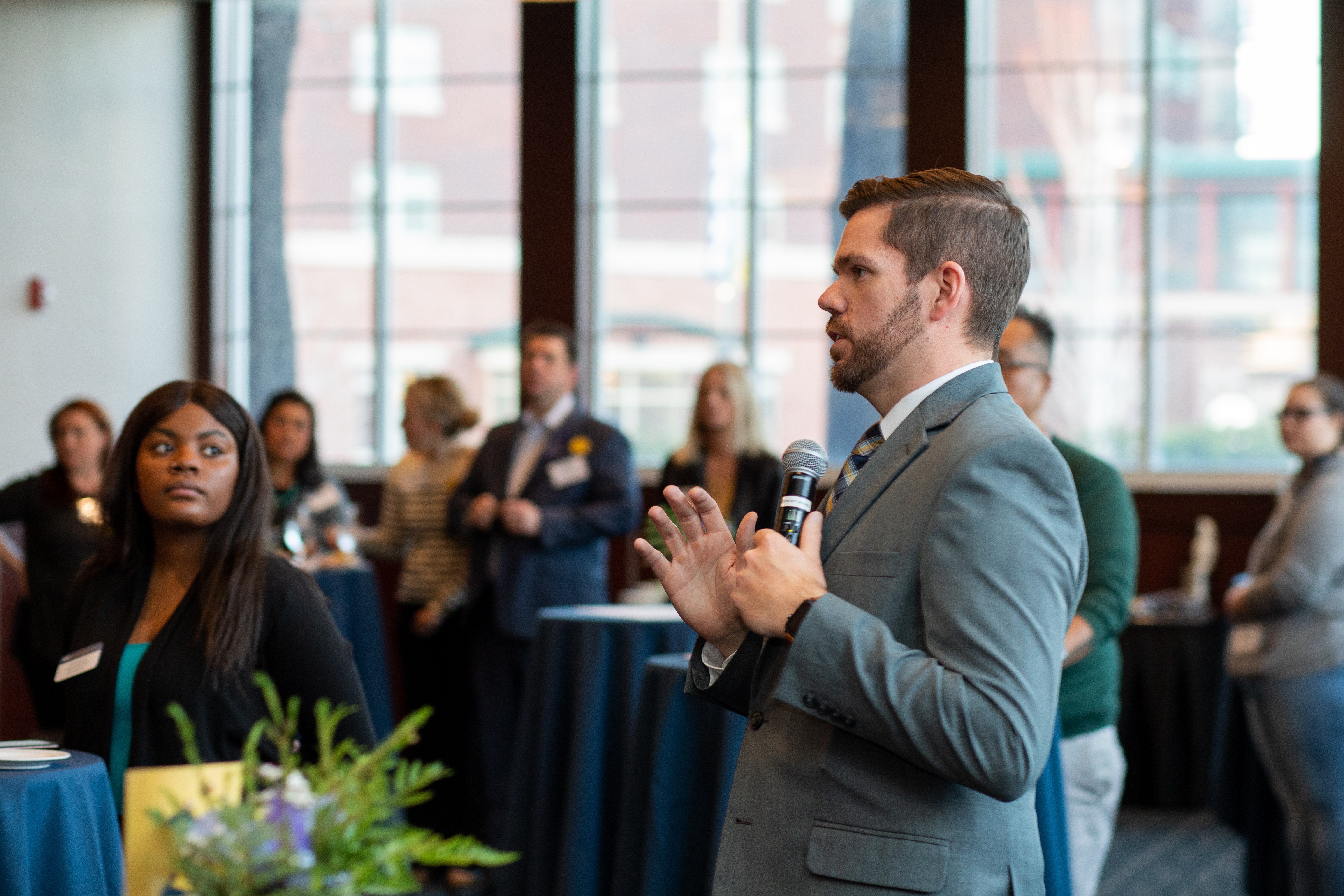 An N A U alumni speaks at an event.