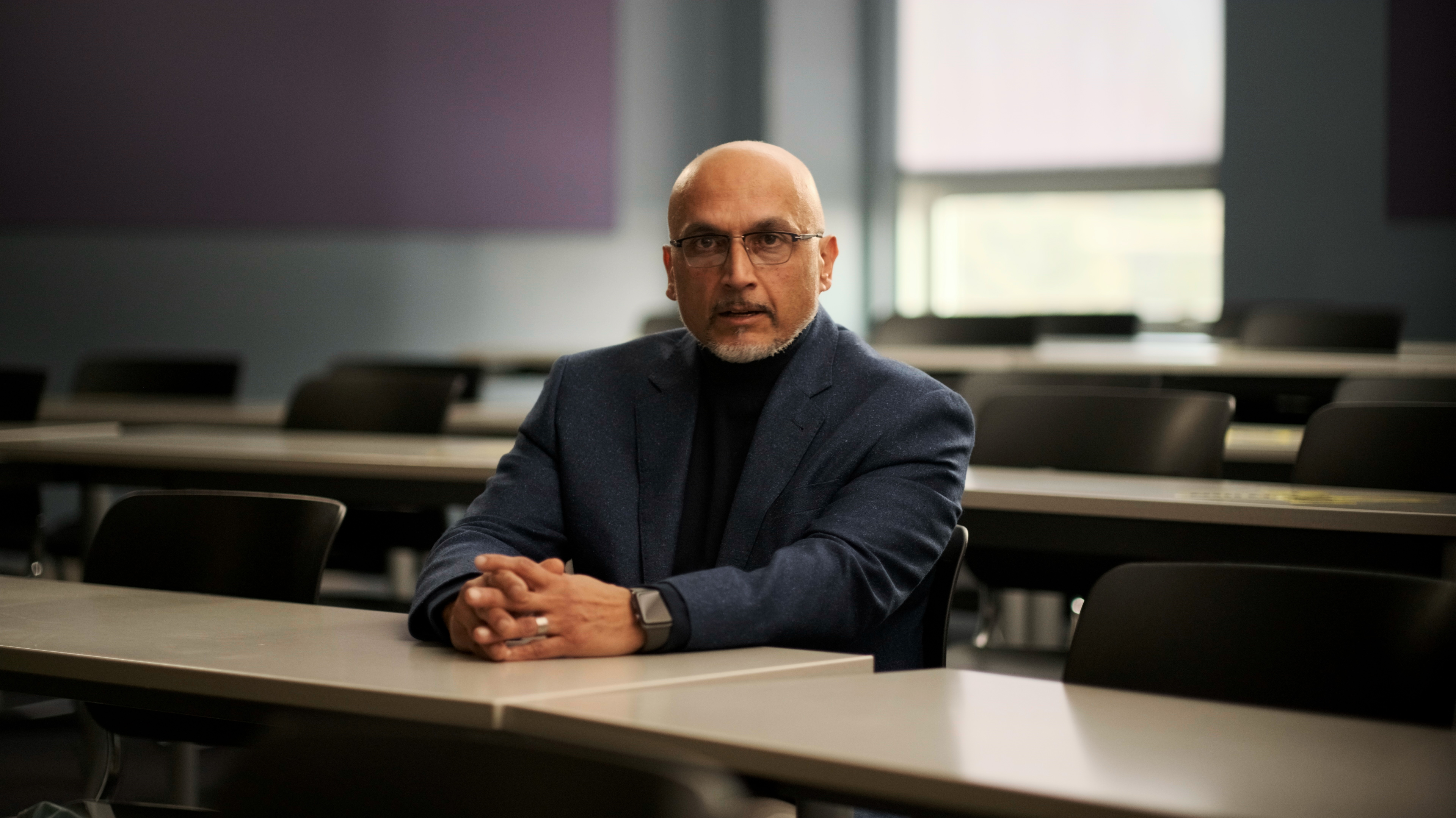 Ashok Subramanian sitting in a classroom.