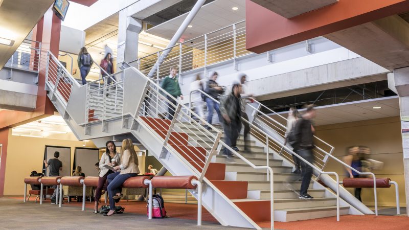 Students walking down stairs in the business college.