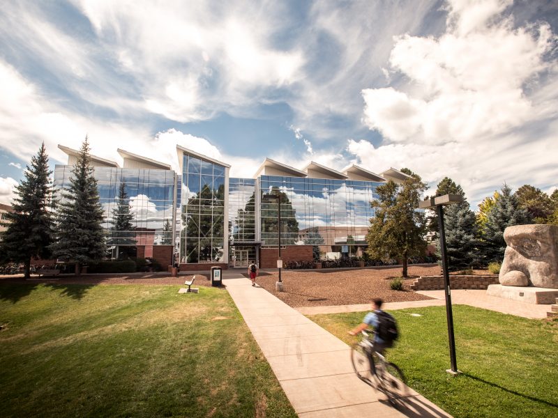 The south campus quad with students riding bikes outside.