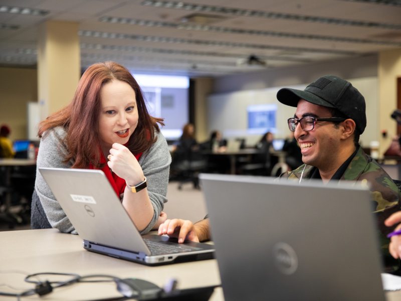 N A U student talks to a mentor in a computer lab.
