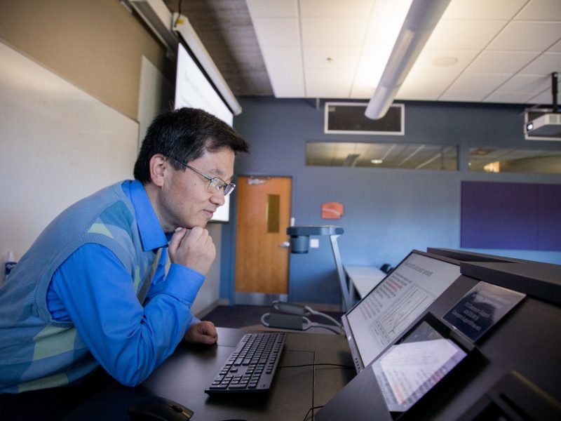 Professor working on their computer in class.