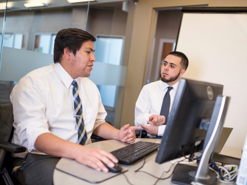 Two students discussing inside The W A Franke building.