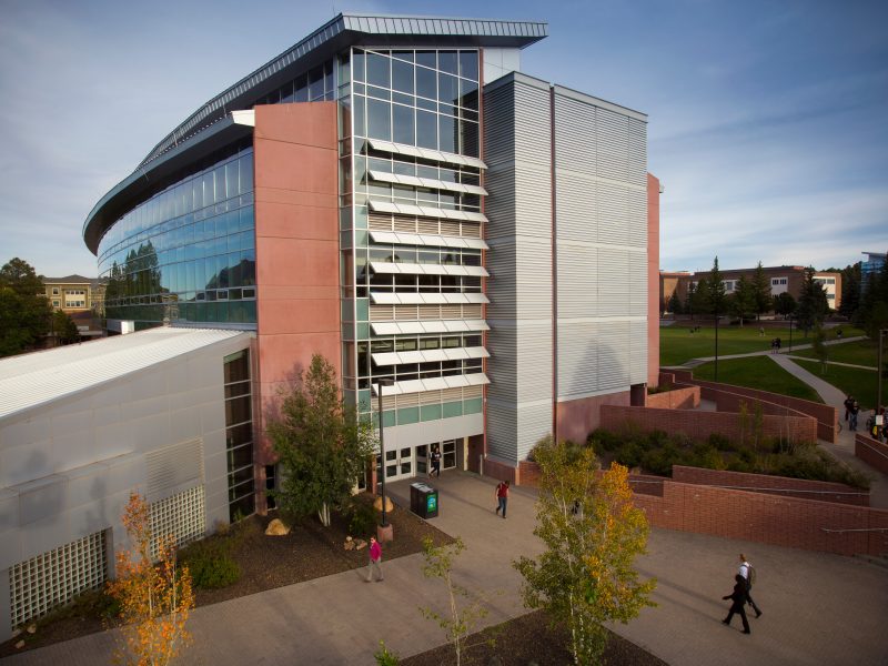 Drone photo showing The W A Franke College of Business building from a birds-eye view with students in the background.