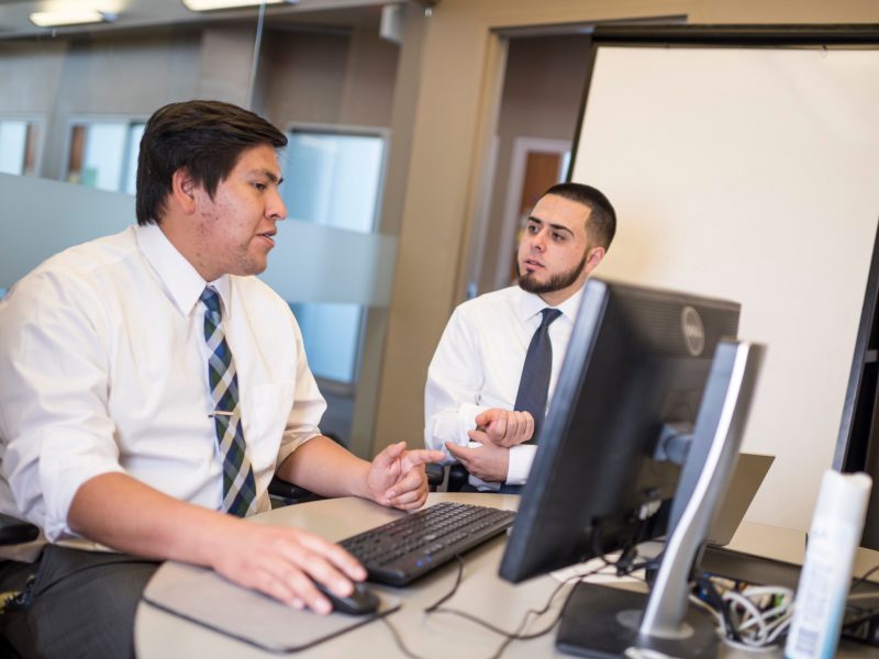 Two students, talking inside The W A Franke Colege of Business building.