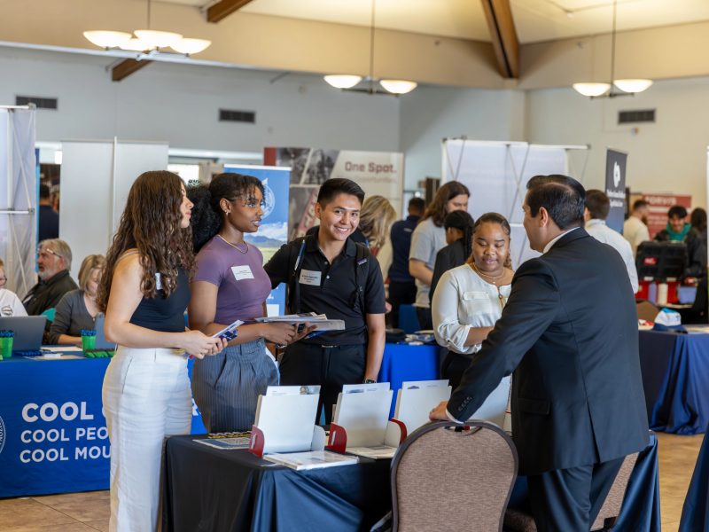 F B C students are listening to someone talk at the career fair.