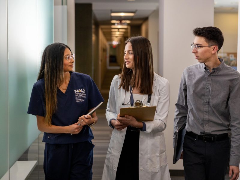 Healthcare administration students walking togethers through a hallway.