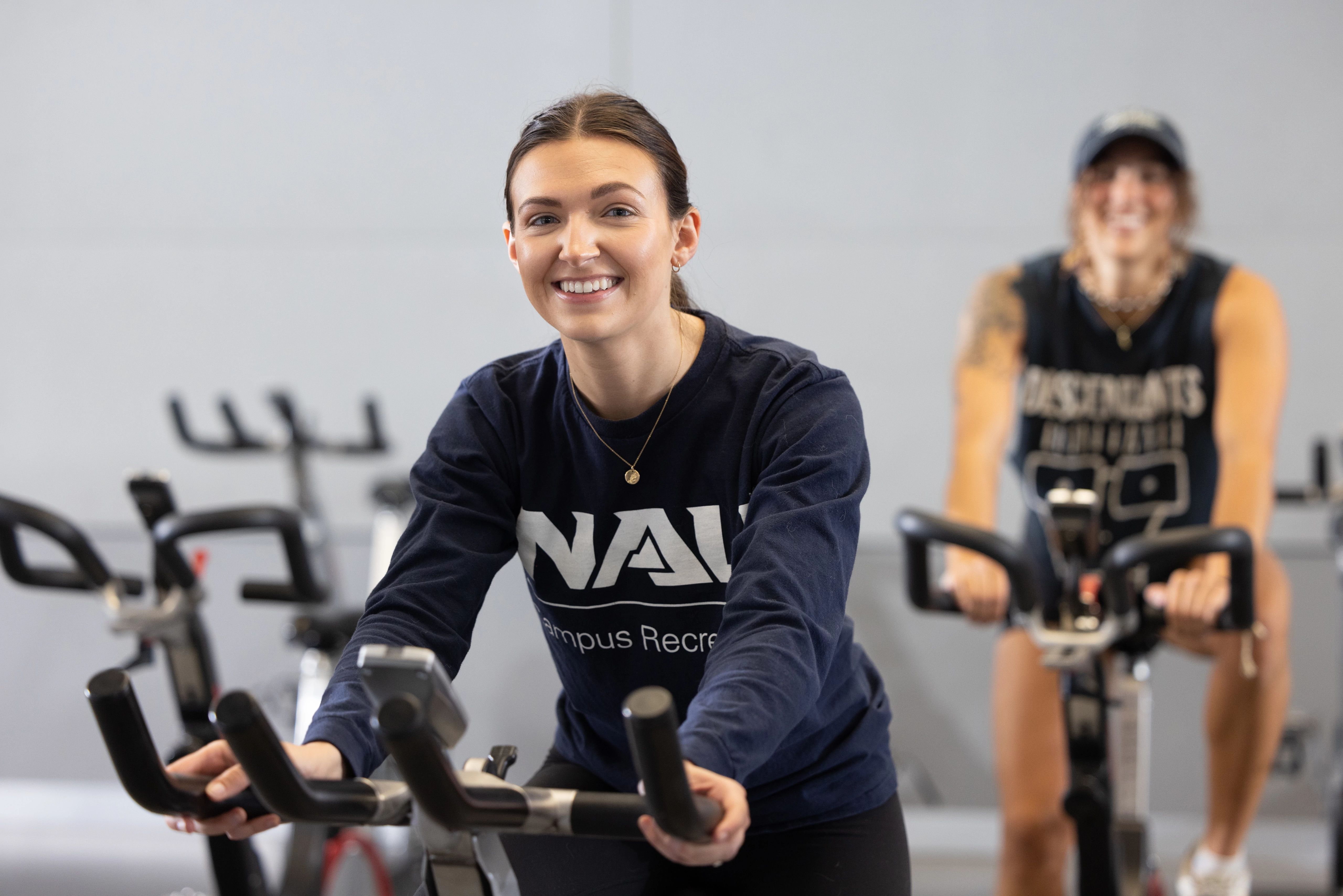 Student smiling while using exercise bike.