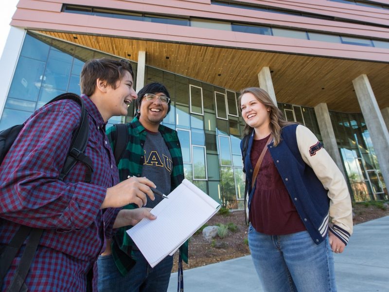 Students talking outside on campus outside of the Science and Health building.