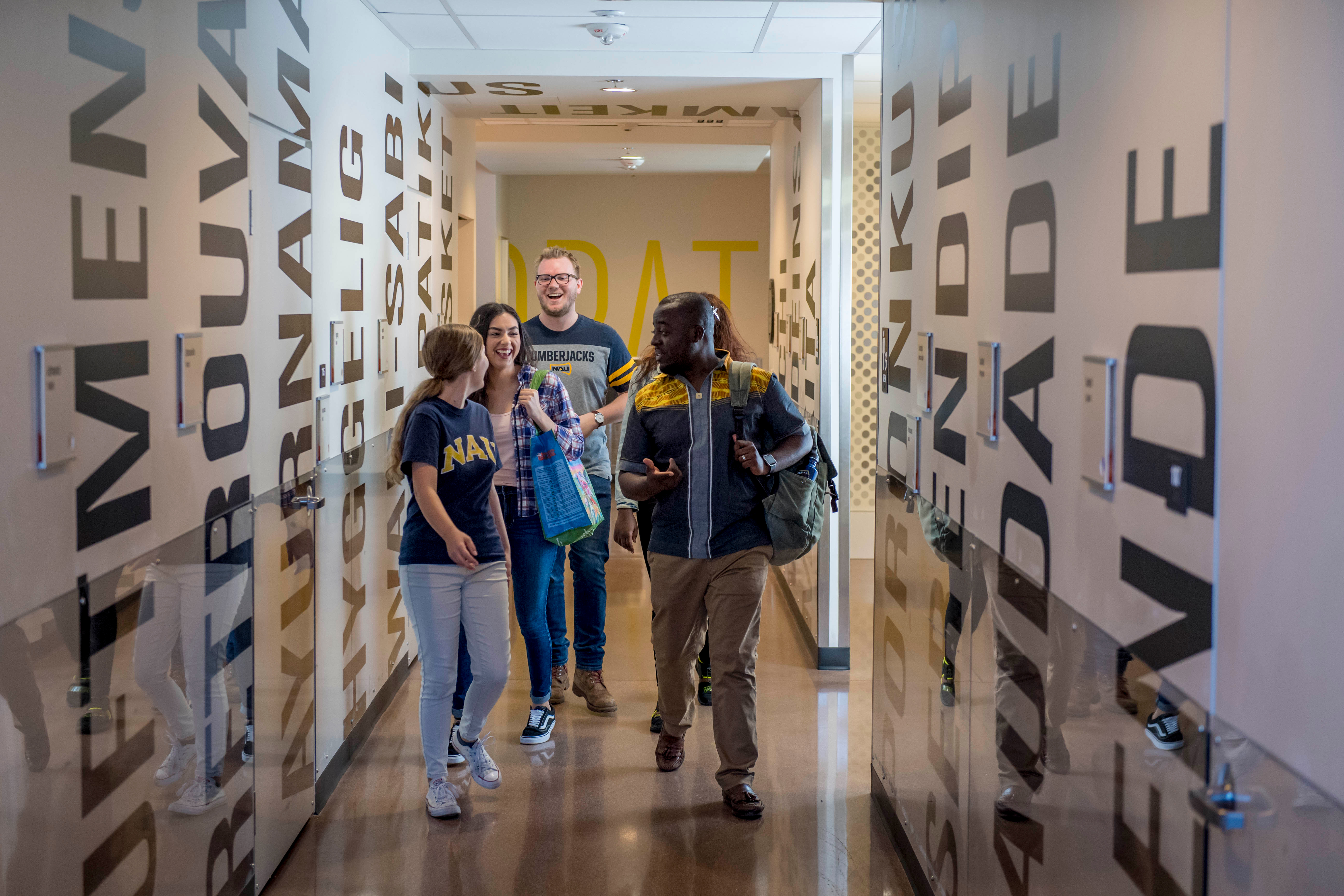 N A U students walking down a hallway and talking.