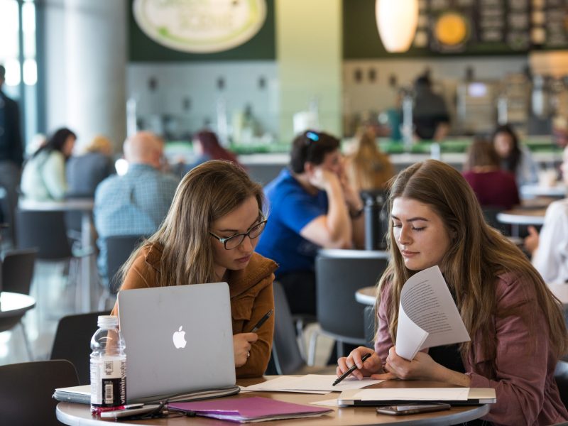 Students working on classwork together in a cafe.