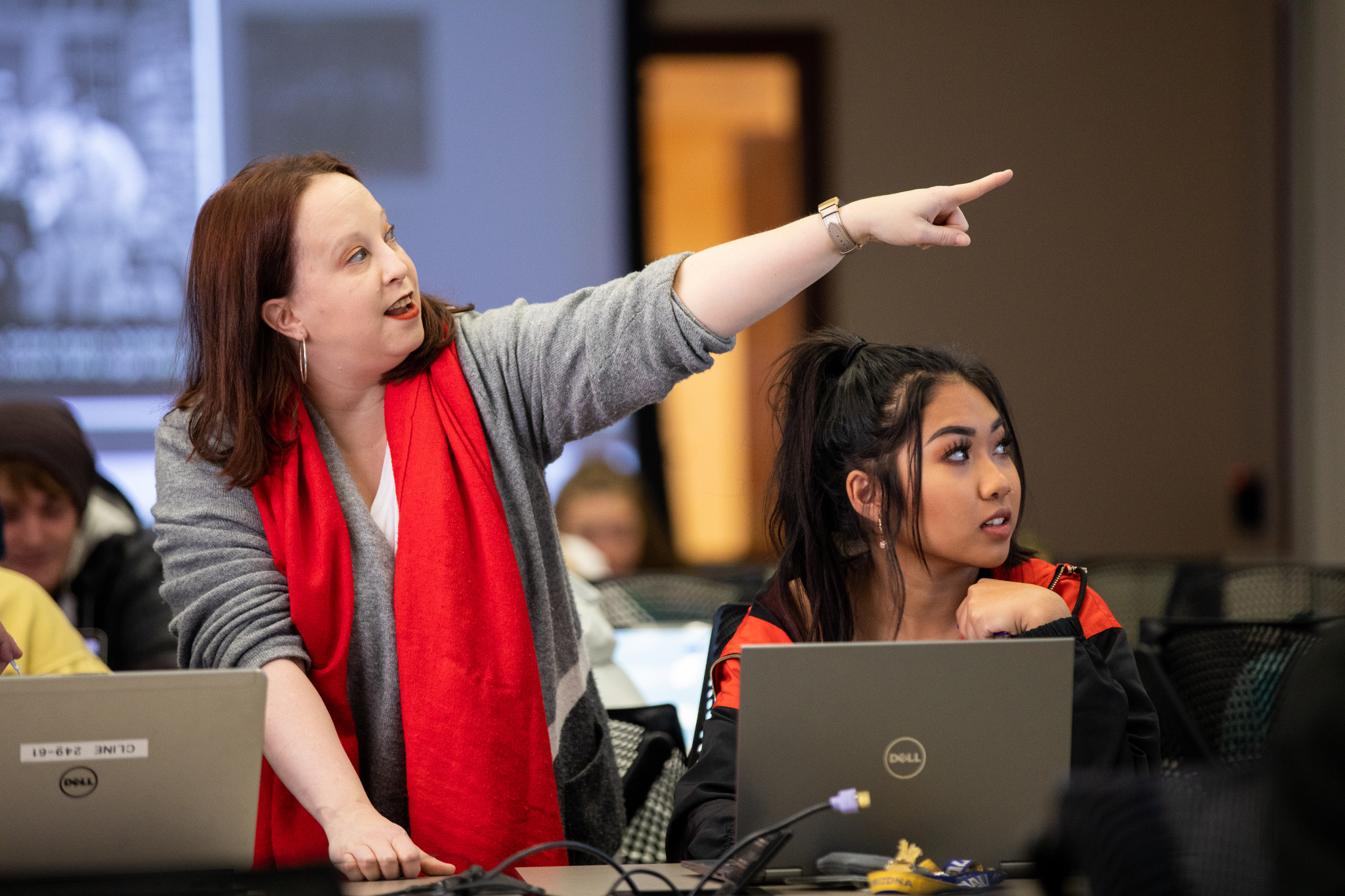 N A U professor stands next to a student and points to a screen.