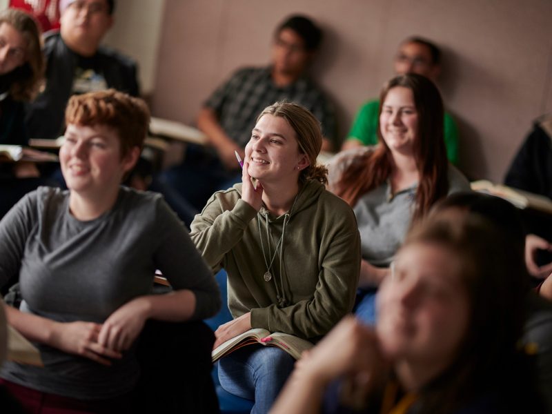 Students sitting in a linguistics class smiling.