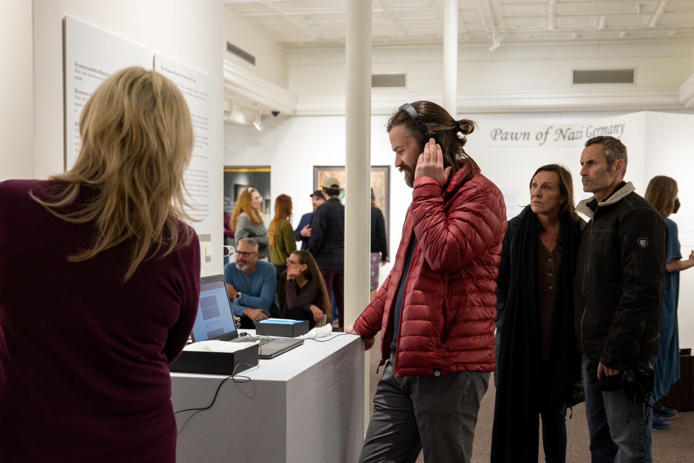 Community members and students at a reception for an art exhibit in campus art gallery.