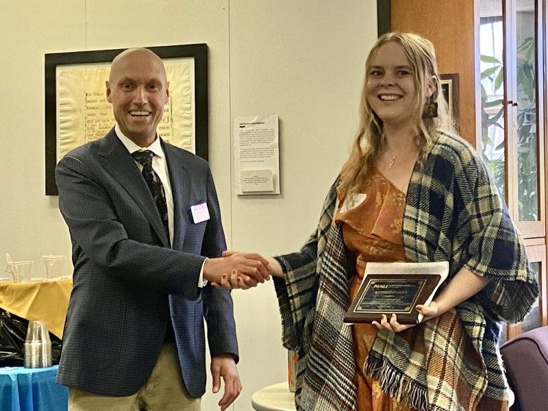 Katherine accepts their award from Dean Boyer on the morning of commencement in the Riles Building.