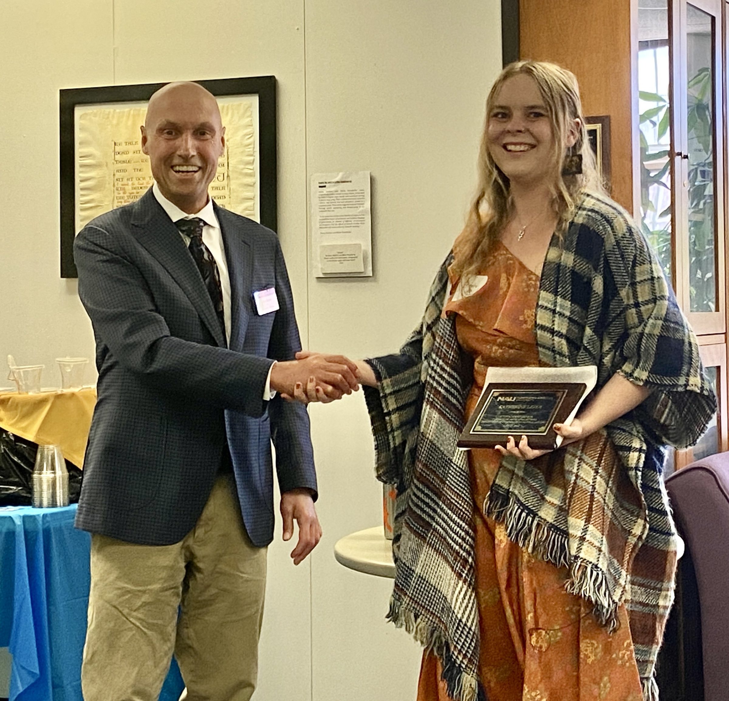Katherine accepts their award from Dean Boyer on the morning of commencement in the Riles Building.