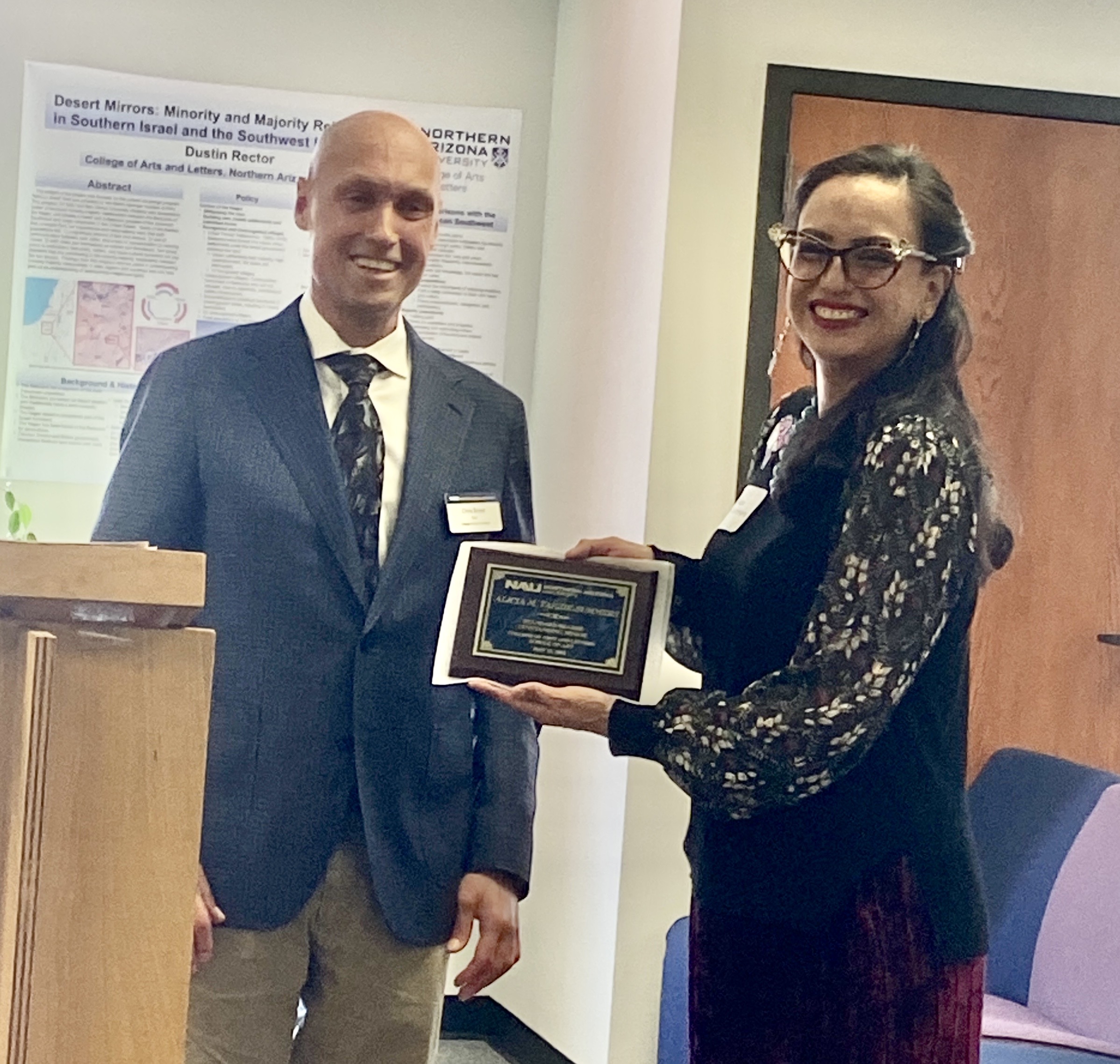 Alicia Yazzie Summers accepts their award from Dean Boyer the morning of commencement in the Riles Building.