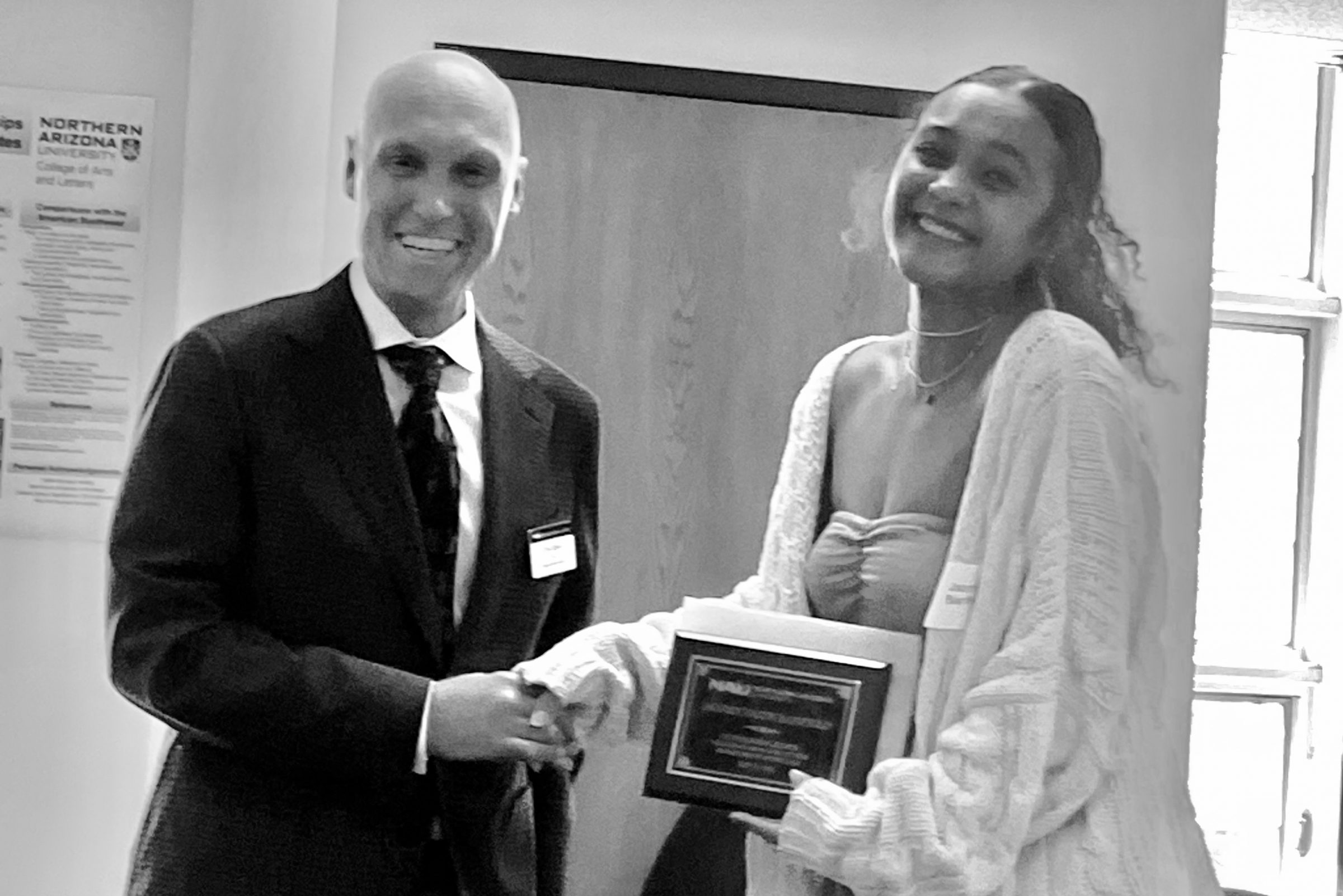 Jaz accepts their award from Dean Boyer on the morning of commencement in the Riles Building.