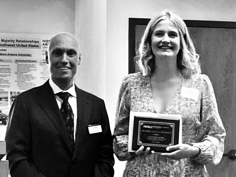 Heather accepts their award from Dean Boyer the morning of commencement in the Riles Building.