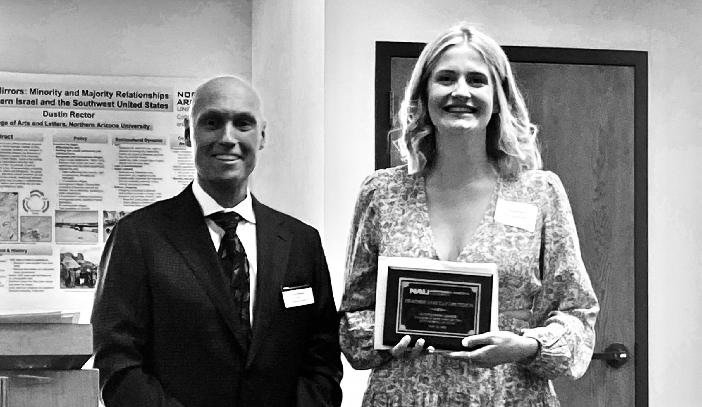 Heather accepts their award from Dean Boyer the morning of commencement in the Riles Building.