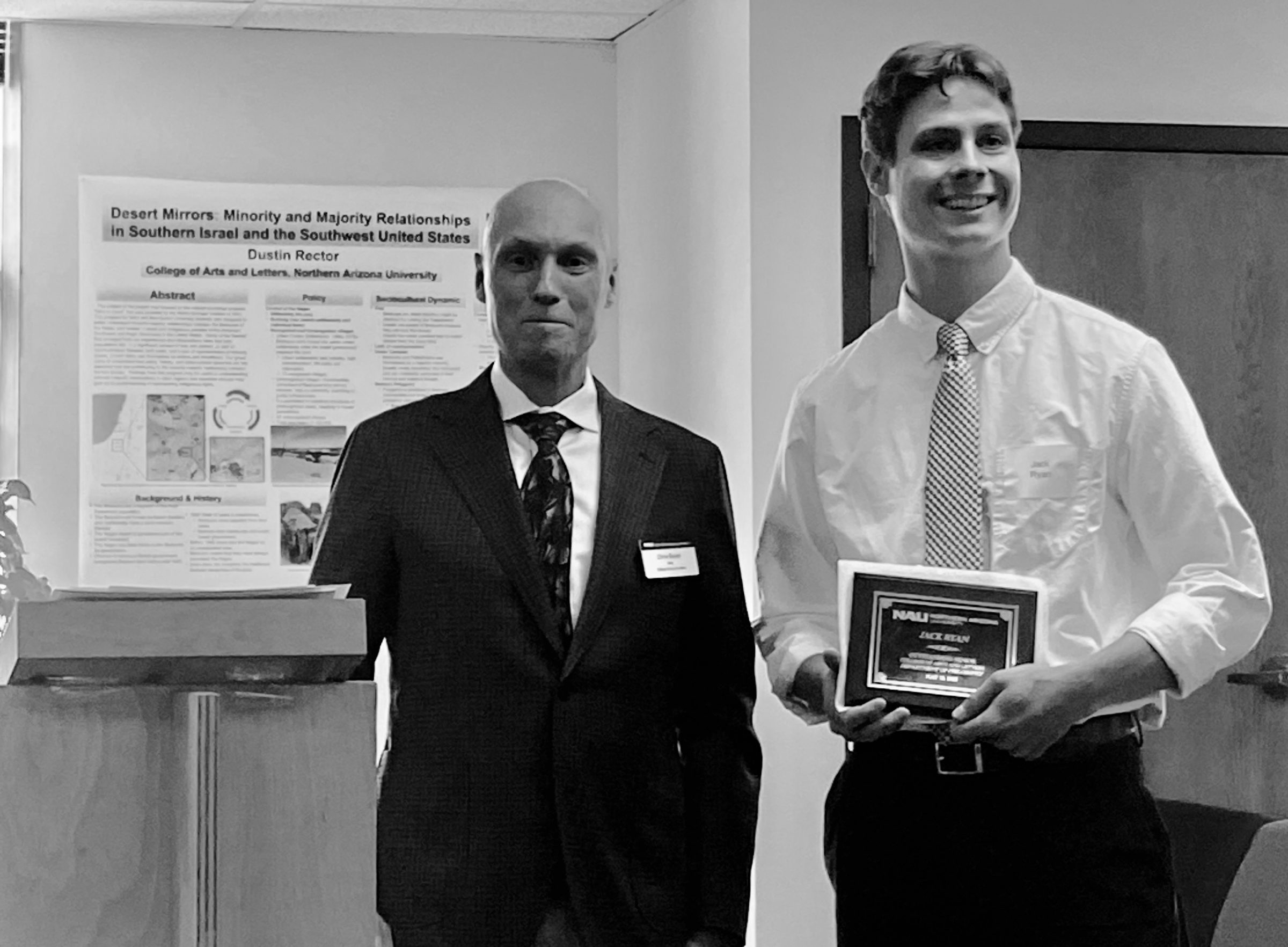 Jack Ryan, Philosophy's Outstanding Senior, accepts their award from Dean Boyer the morning of commencement in the Riles Building.