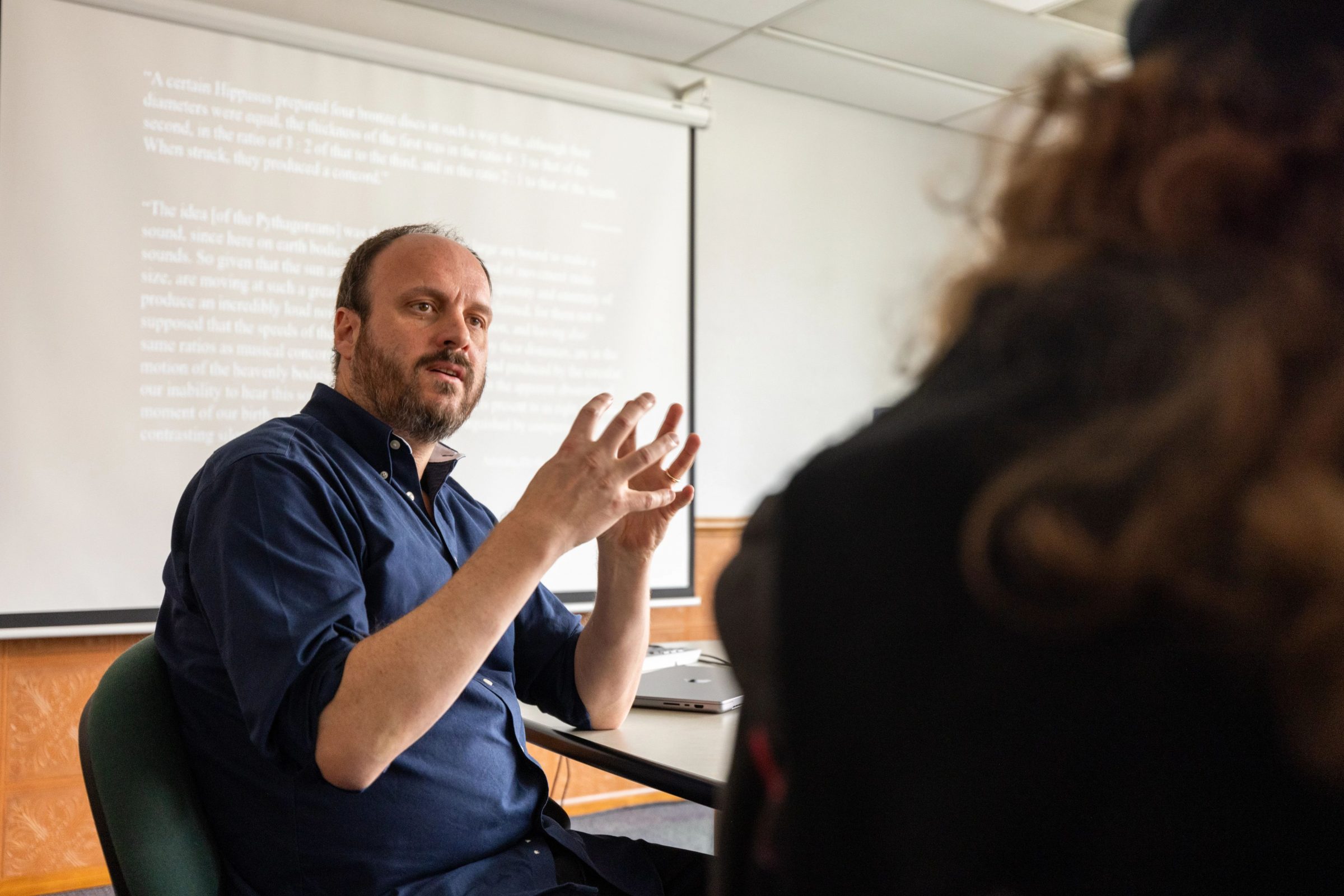 Doctor Gregory Kirk talking with student at large table.