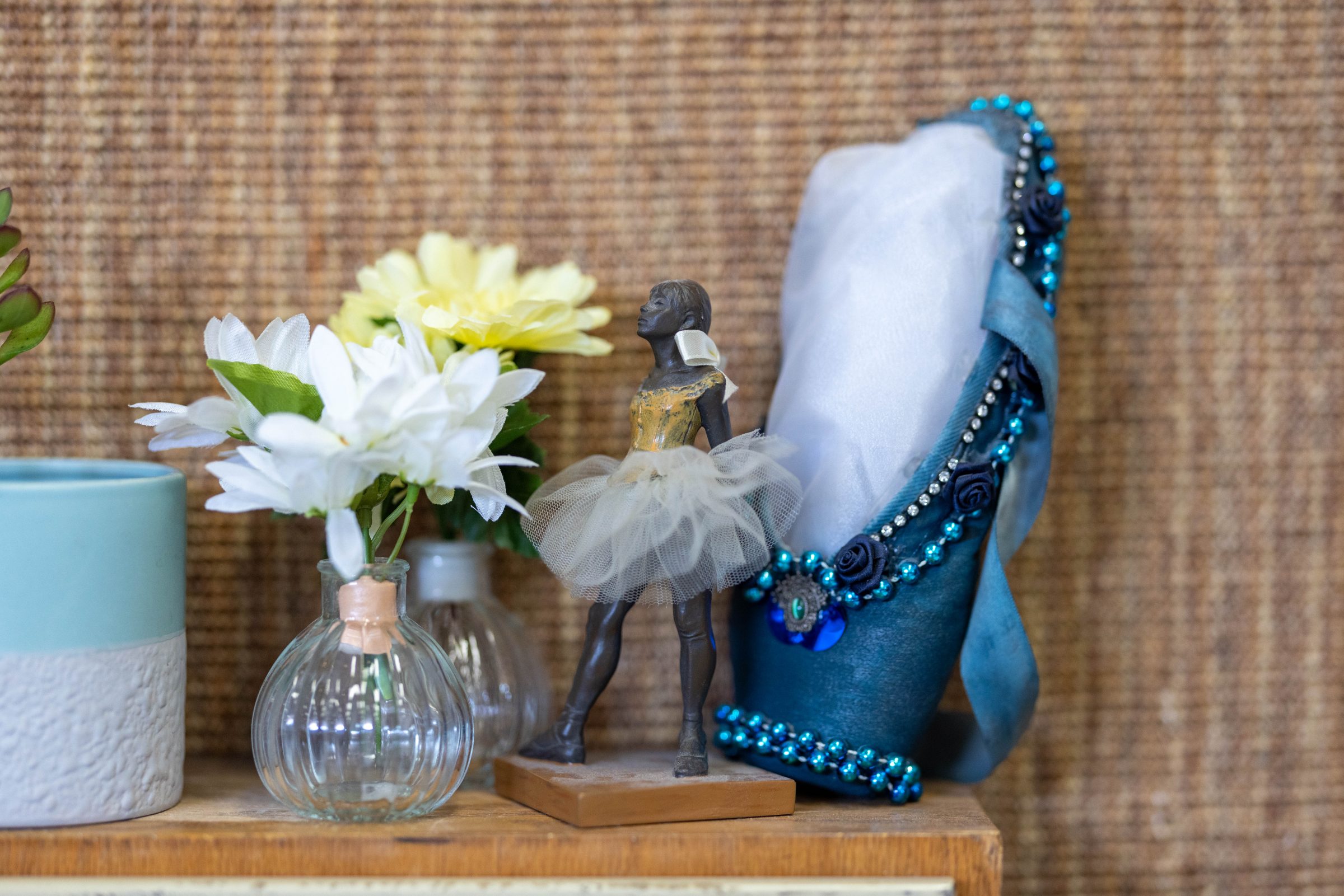 A statue of a ballerina next to flowers in vases.