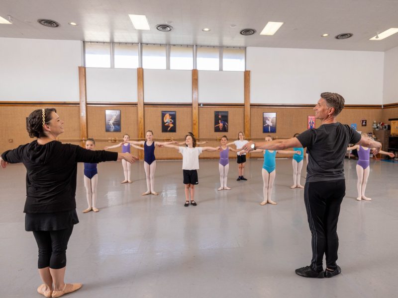 Two ballet instructors leading students.