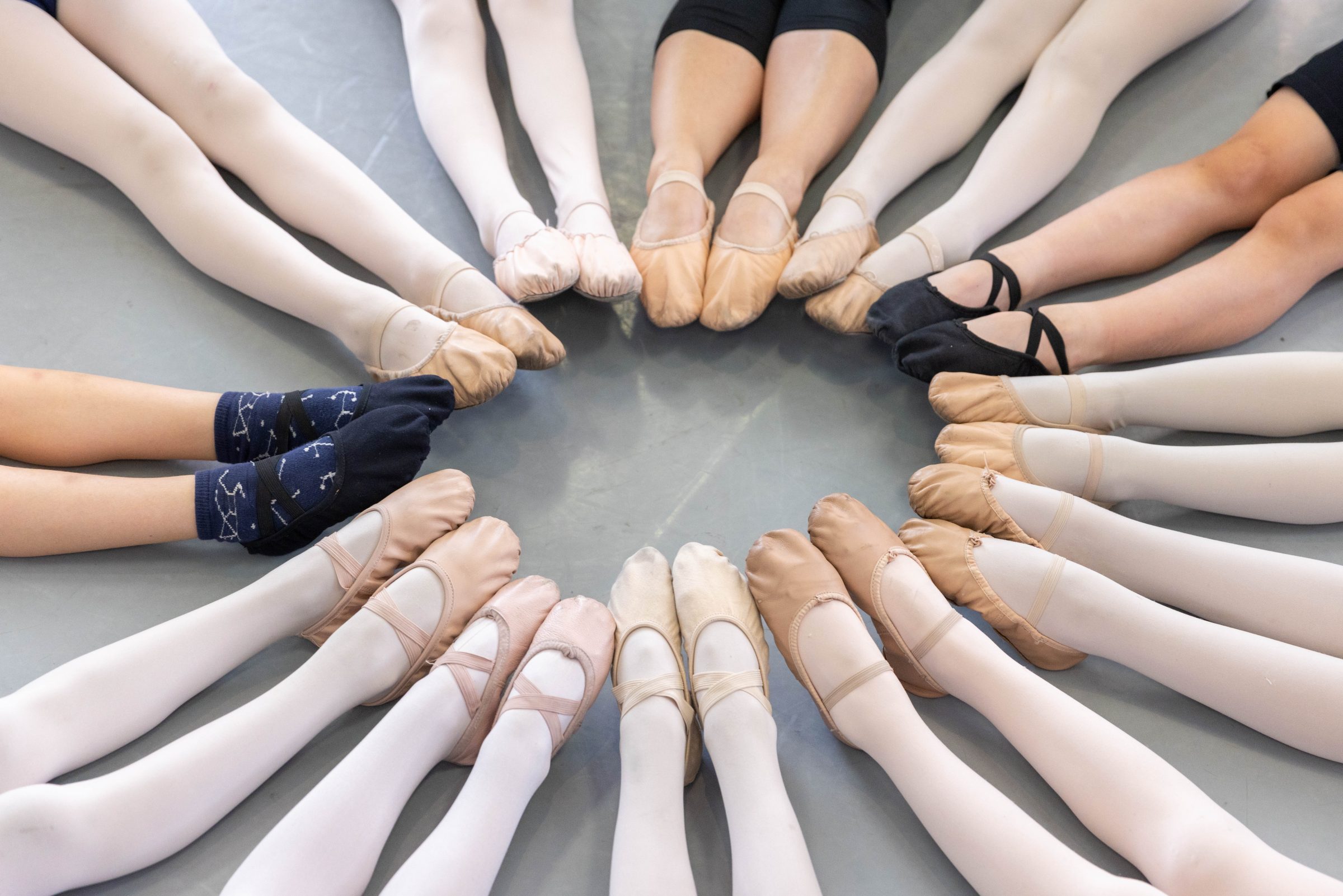 A picture of ballerina shoes all lined up in a circle together.