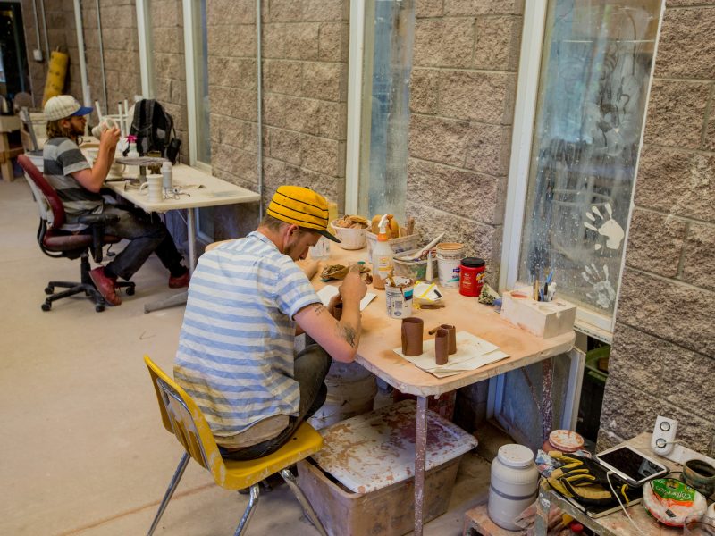 Students working on their ceramics at a table.