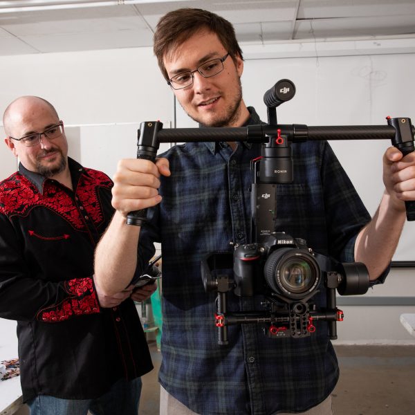 Professor and student testing a handheld camera gimbal.