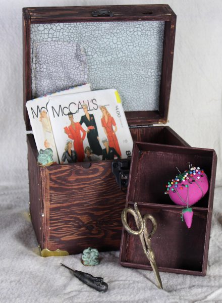 A sewing box filled with an assortment of objects.