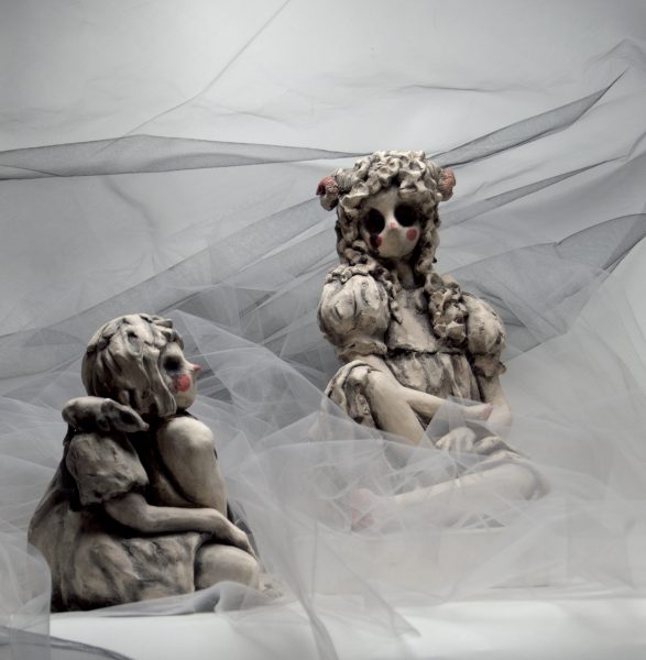 Two sculptures in dresses set up together.