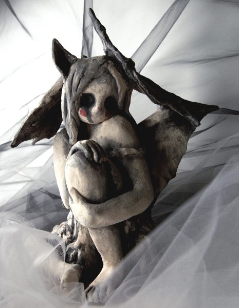 Front view of a humanoid sculpture with wings.