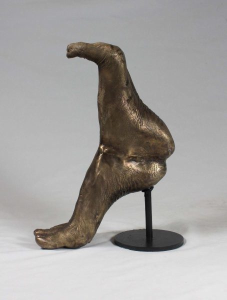 Sculpture of bronze human feet in heel toe formation.