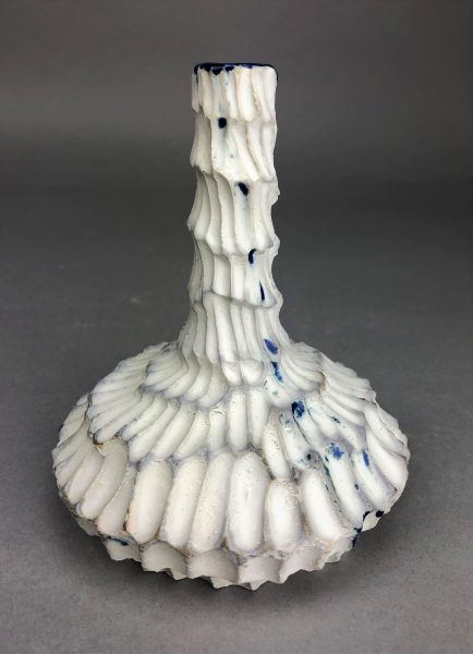 A white and blue, scaled, ceramic vase-like sculpture called "Sky."