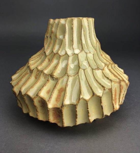 A yellow, scaled, ceramic sculpture called "sunflower."