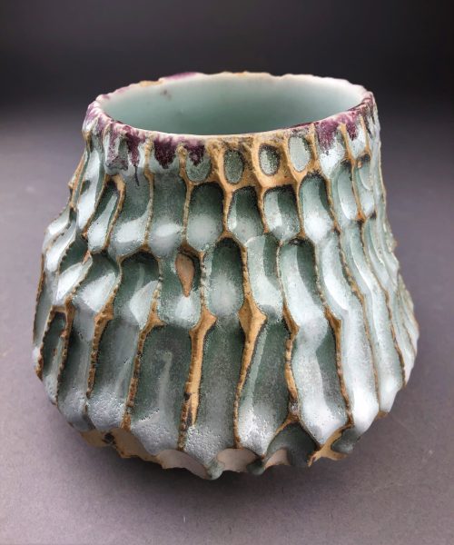 A teal and violet ceramic, scaled sculpture.
