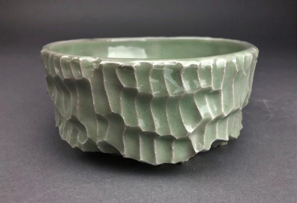 A green scaled ceramic bowl.