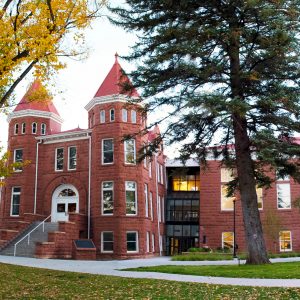 Front of NAU's Old Main surrounded by trees and grass